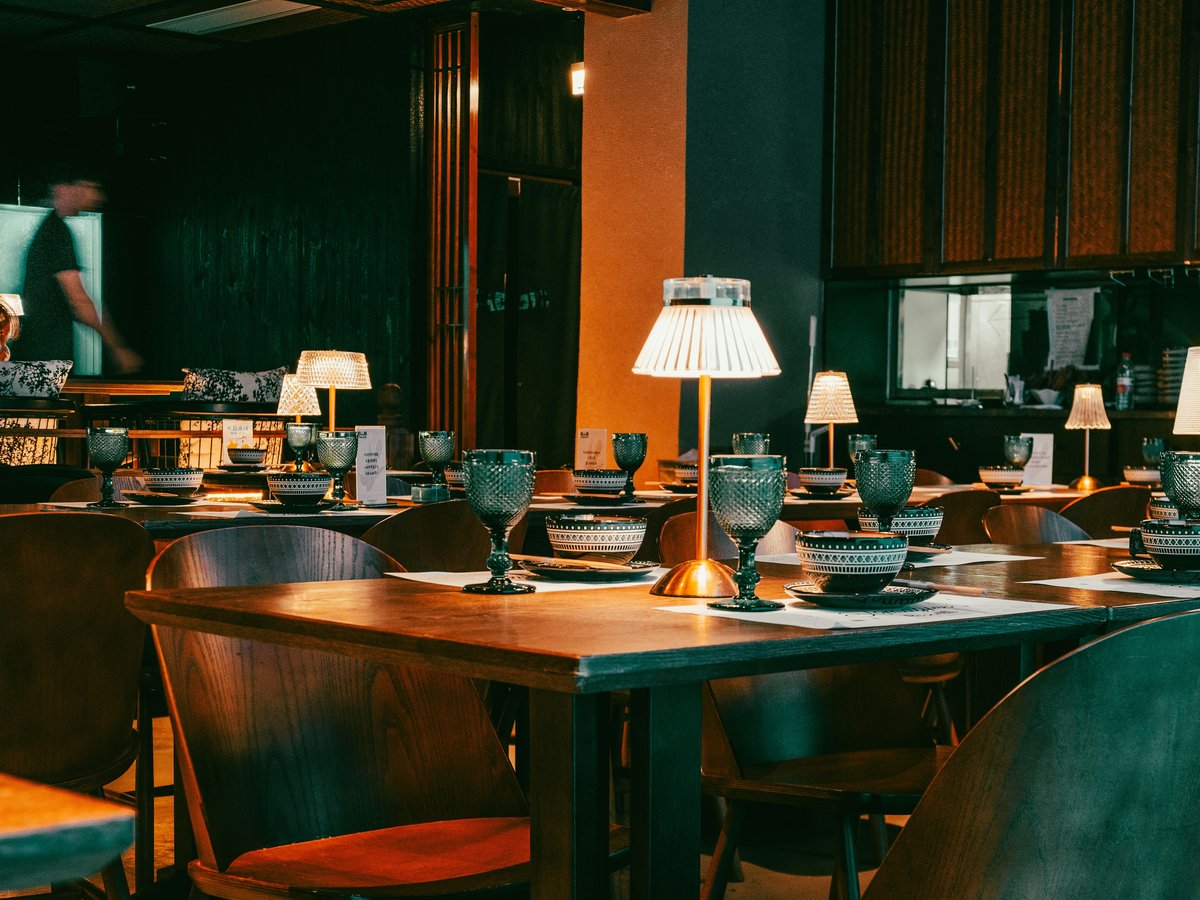 Restaurant dining tables set with tableware and lamps