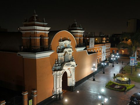 A city street at night with a clock tower in the background