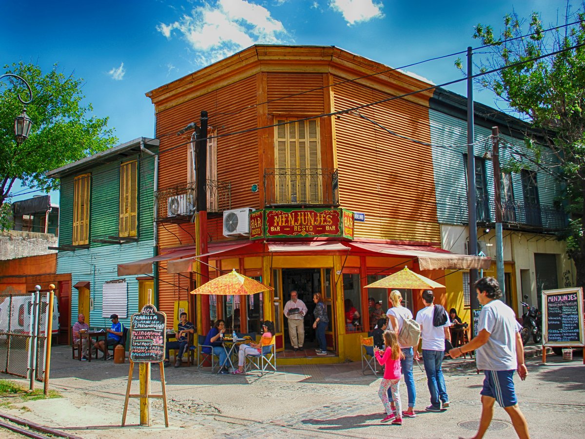 people walking on street near brown wooden building during daytime