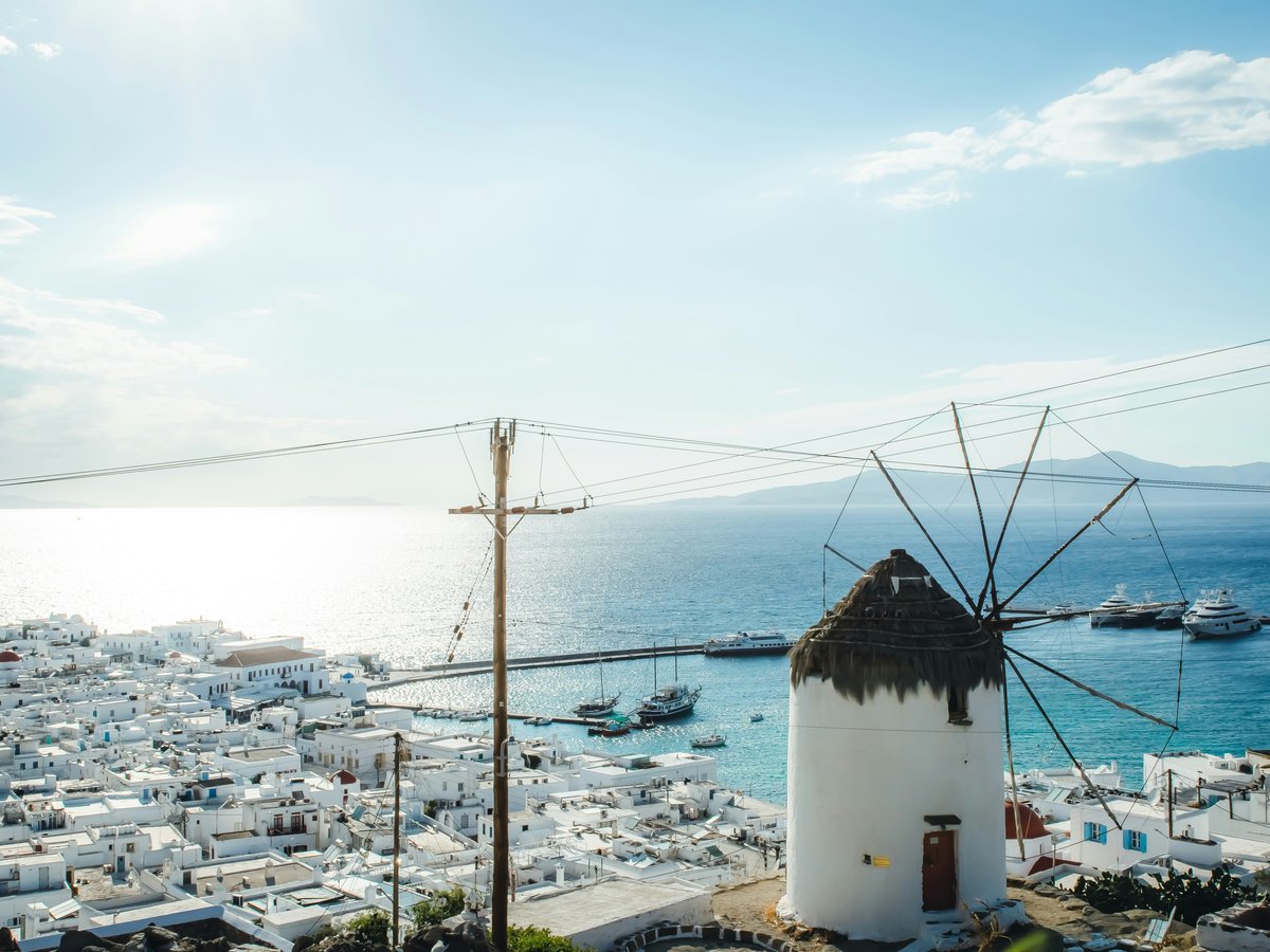 a windmill in the middle of a town by the ocean