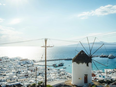 a windmill in the middle of a town by the ocean