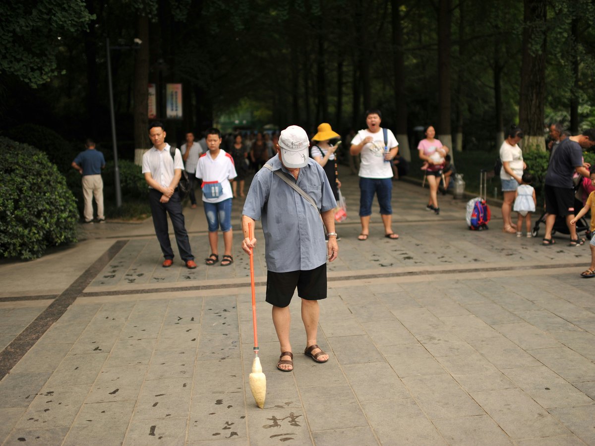 Elderly man playing with a spinning top outdoors