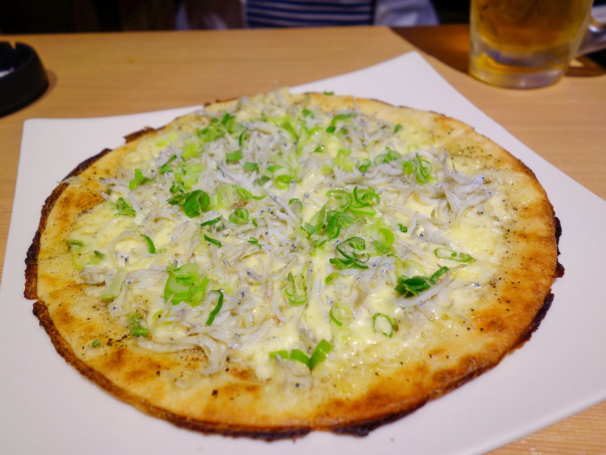 Round pizza topped with whitebait and green onions