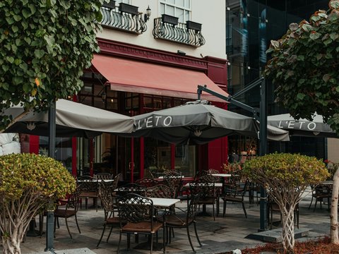 A group of tables and chairs outside of a restaurant