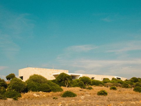 a building sitting on top of a lush green hillside