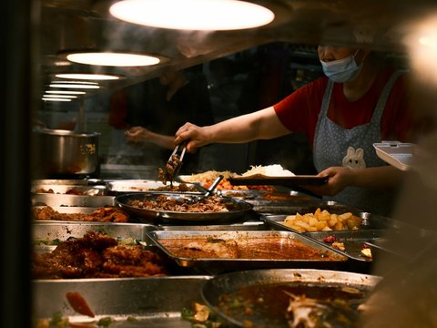 A restaurant kitchen with a lot of food on the counter