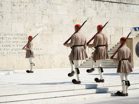 group of people in red and brown uniform playing ice hockey