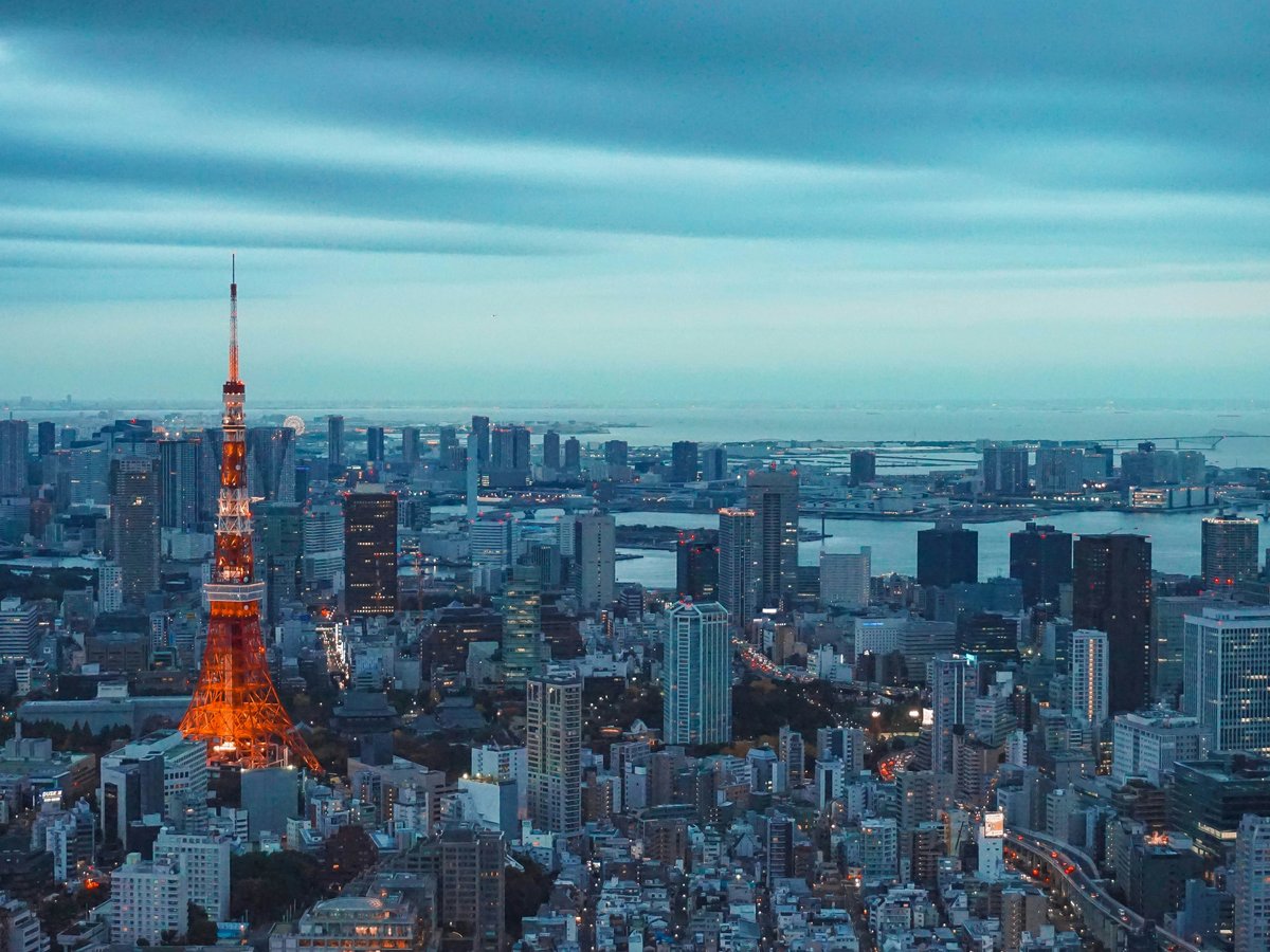 tokyo tower illuminated at dusk with city skyline
