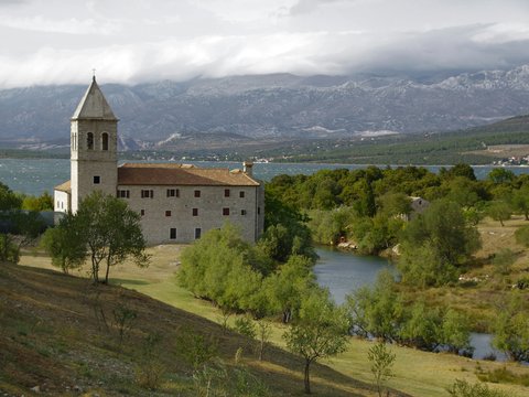 a large building sitting on top of a lush green hillside