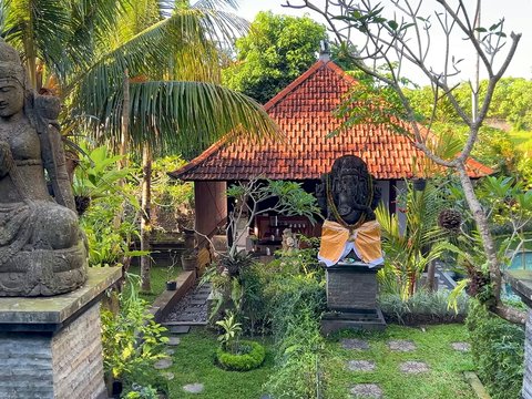 a garden with statues of buddhas and a gazebo