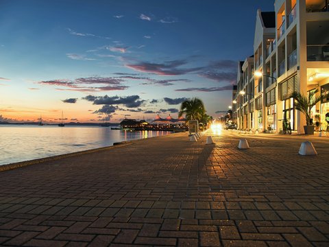 a street lined with tables next to a body of water