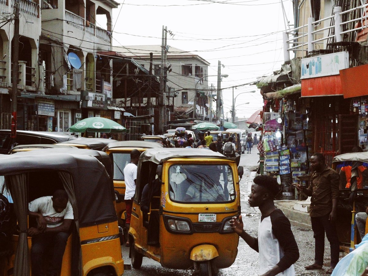 people on street and different vehicles near buildings during daytime