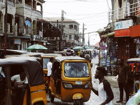 people on street and different vehicles near buildings during daytime