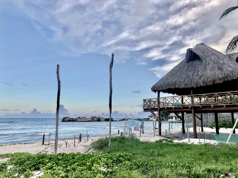 a hut on a beach next to the ocean
