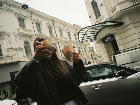 a woman holding a cup of coffee in front of her face