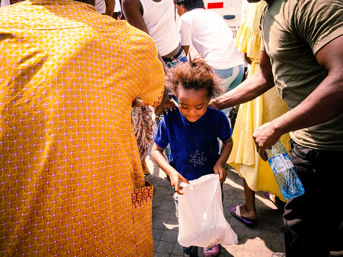 a little girl holding a white bag in her hands