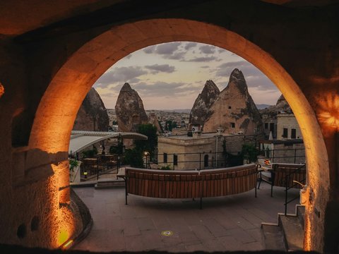 Fairy chimneys and buildings viewed through an archway.