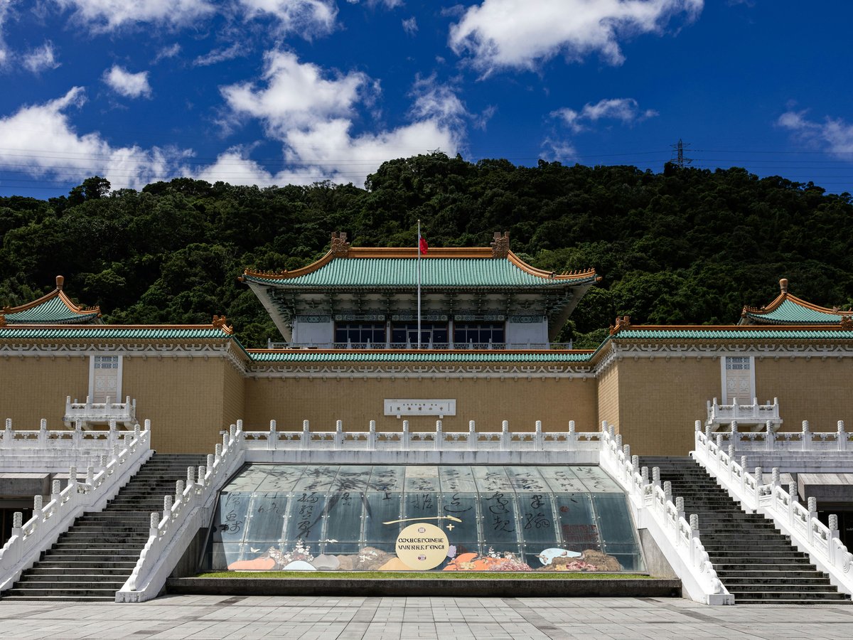 National palace museum with lush green hill background