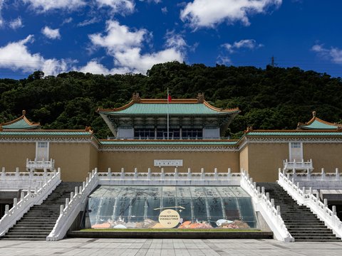 National palace museum with lush green hill background