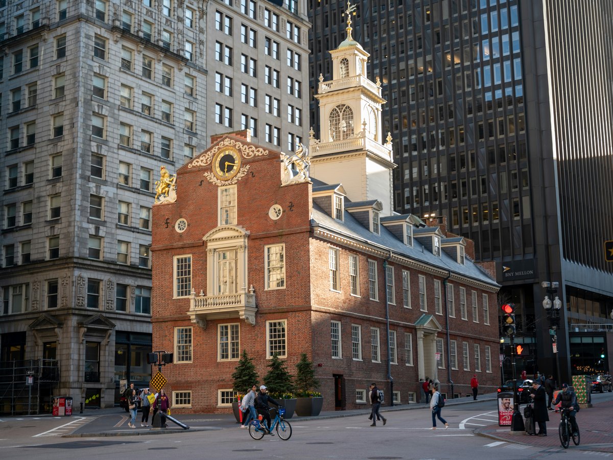 a brick building with a clock tower with Old State House in the background