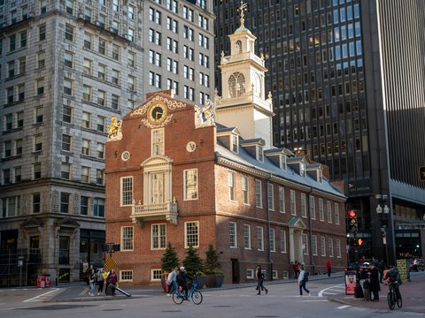 a brick building with a clock tower with Old State House in the background