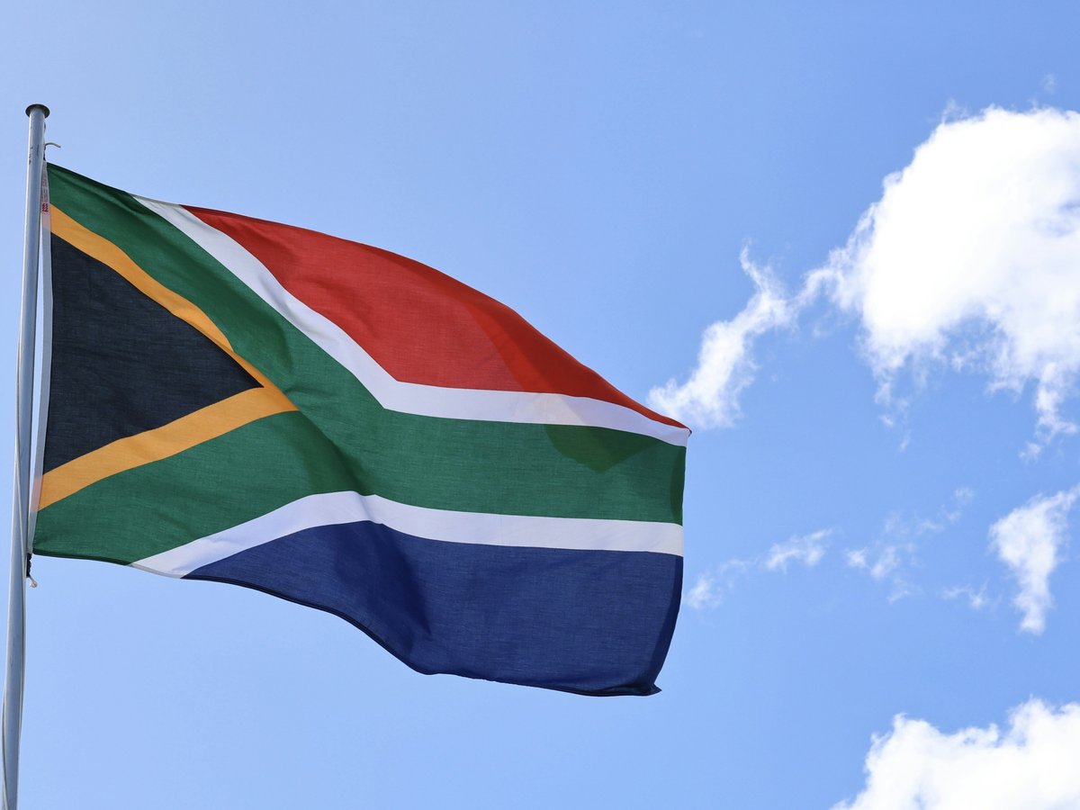 a flag flying in the wind on a sunny day