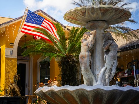 Fountain in front of a yellow building with american flag.