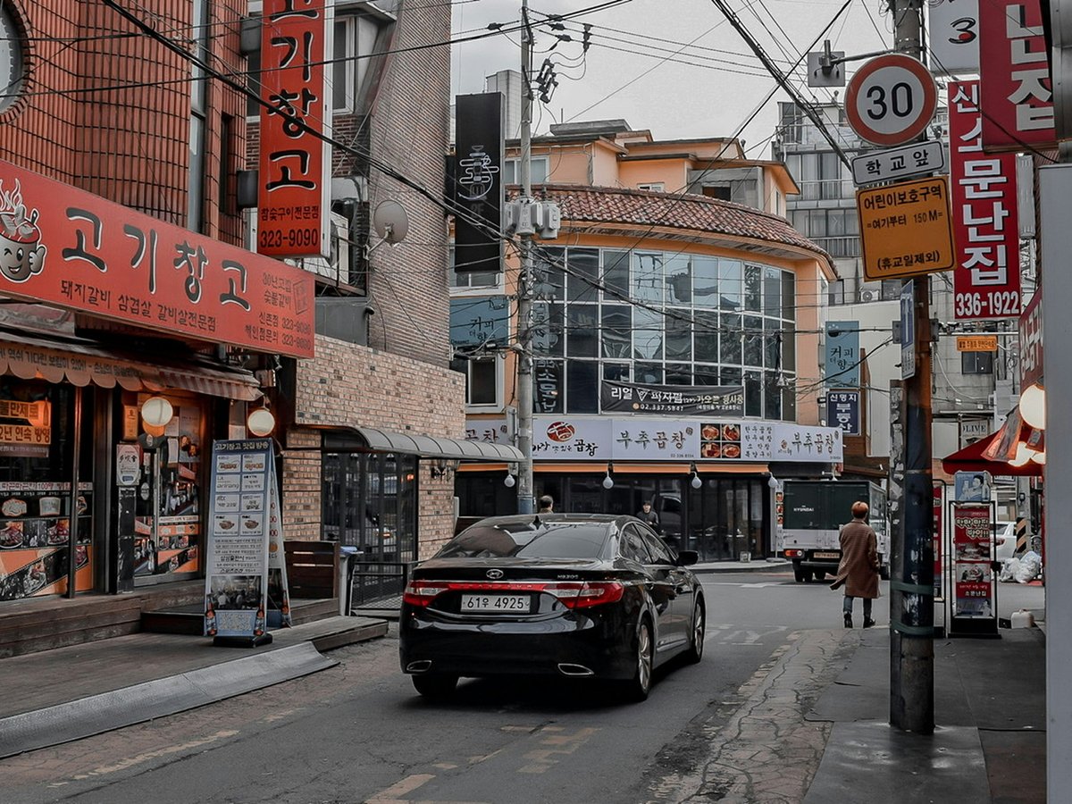black car parked beside brown concrete building during daytime