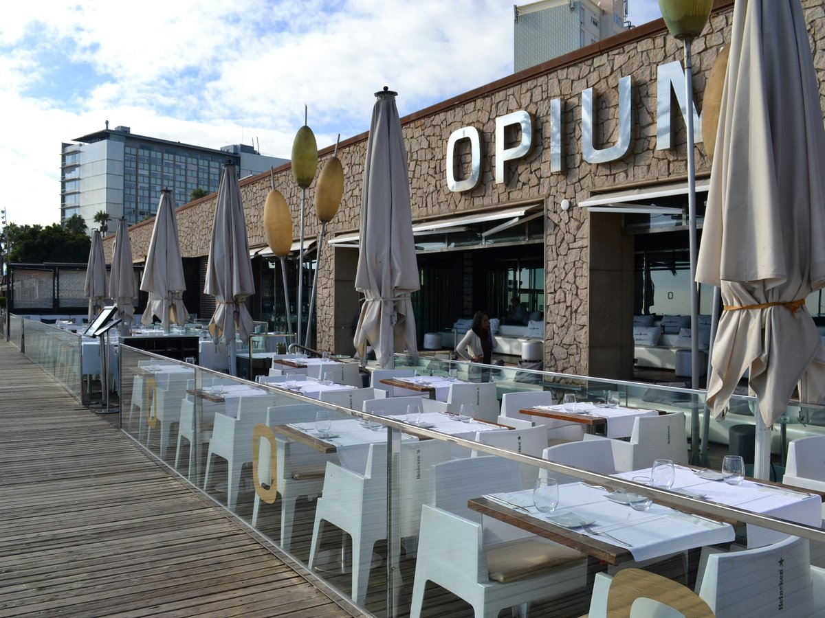 a row of tables with umbrellas outside of a restaurant