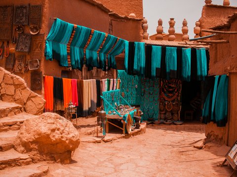 assorted-color textiles hanged beside concrete buildings
