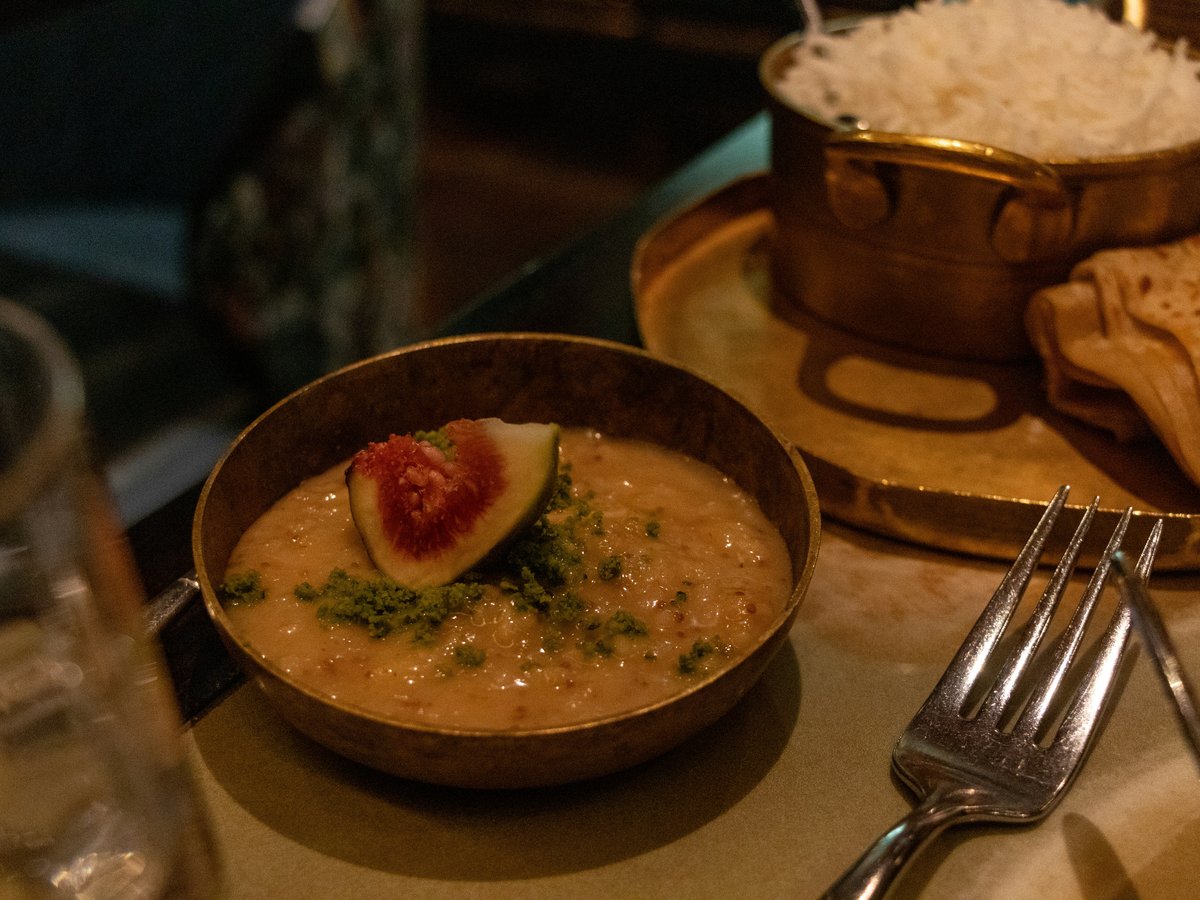 A bowl of soup and a plate of bread on a table