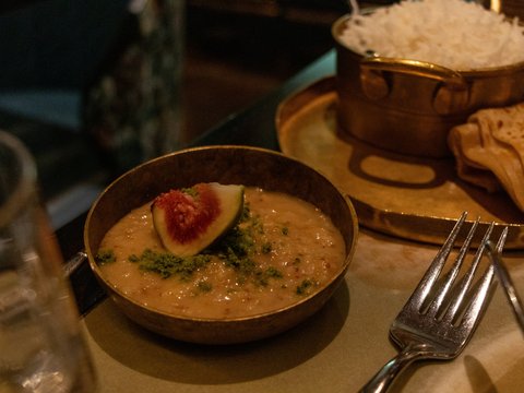 A bowl of soup and a plate of bread on a table