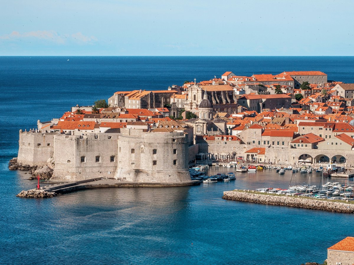 white and red concrete houses beside sea