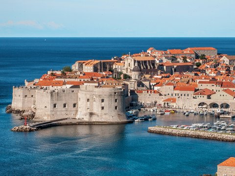 white and red concrete houses beside sea
