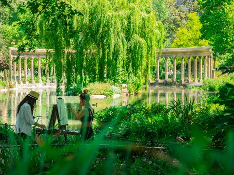 man and woman painting near body of water