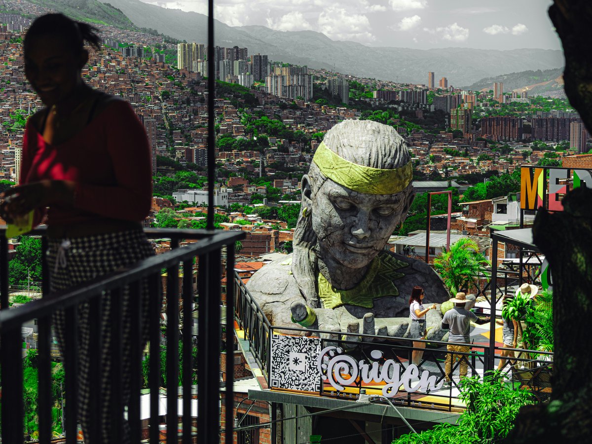 A woman standing next to a statue of a man