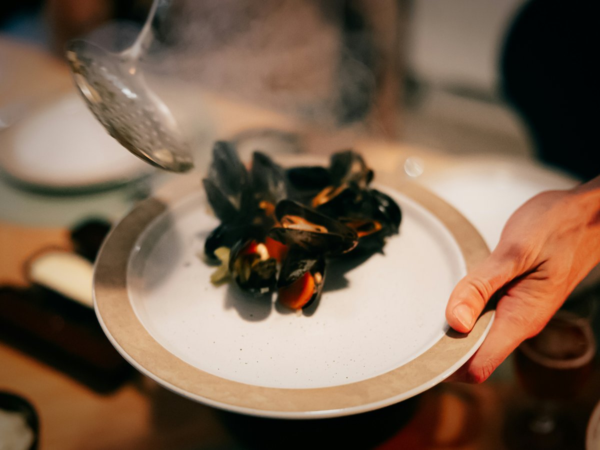 a plate of mussels being served on a table