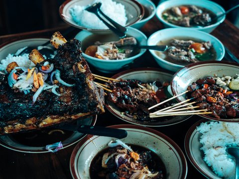 a table topped with plates of food and bowls of rice