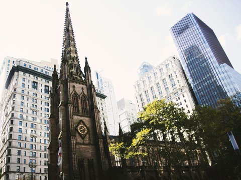 a tall church tower towering over a city filled with tall buildings