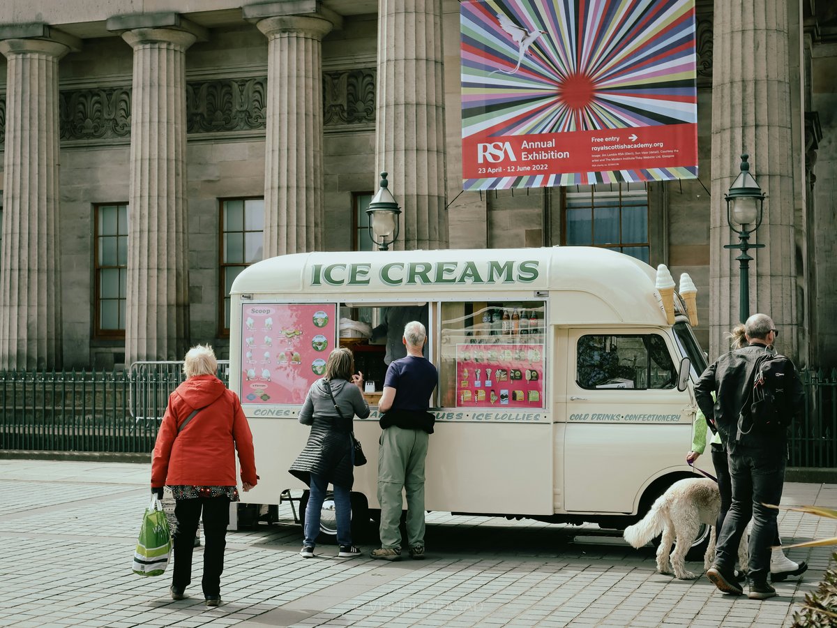 a group of people standing in front of a ice cream truck