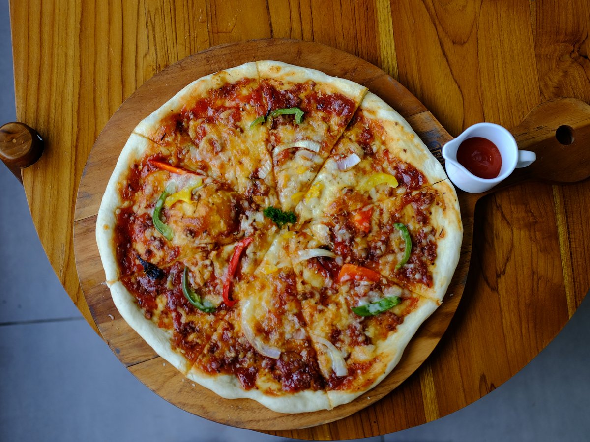 a pizza sitting on top of a wooden table
