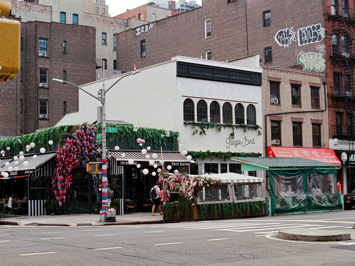 a street with a building and flowers
