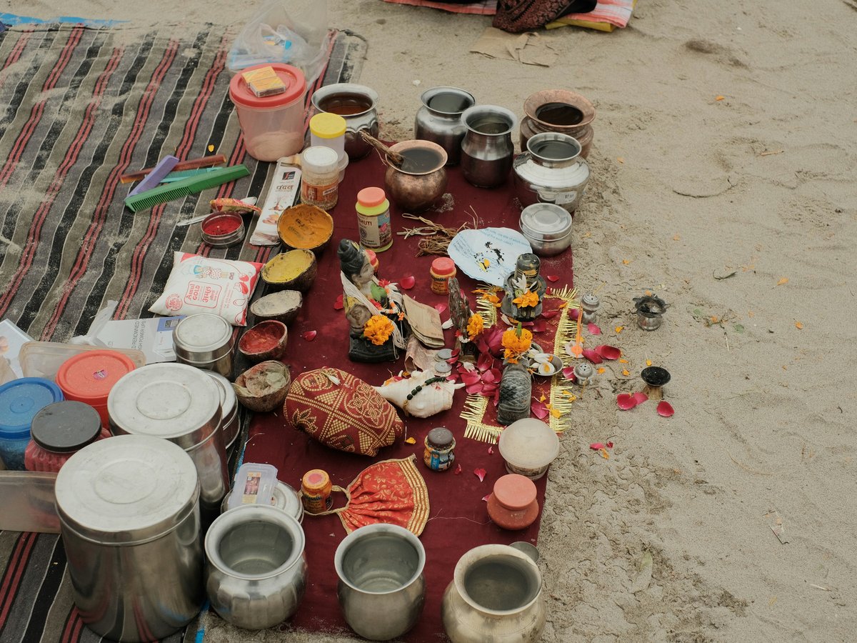 a blanket on a beach covered in pots and pans