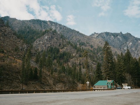green and white house near green trees and mountain during daytime