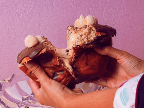 a person is holding a half eaten pastry