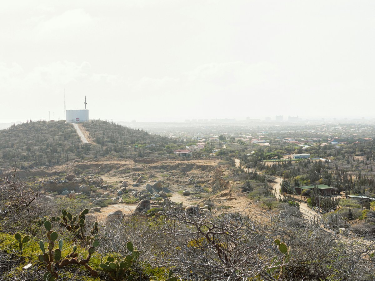 a view of a desert with a hill in the background