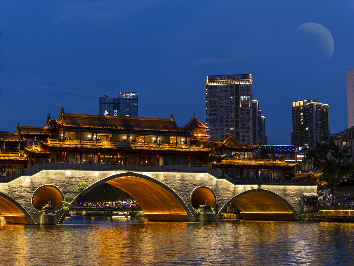 A bridge over a body of water with buildings in the background