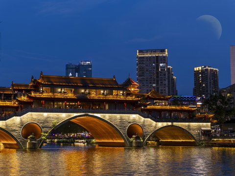 A bridge over a body of water with buildings in the background