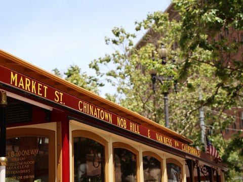 A red and yellow bus parked in front of a building