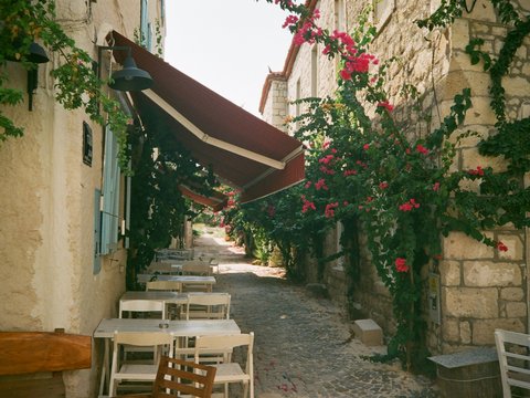 A narrow street with tables and chairs on it